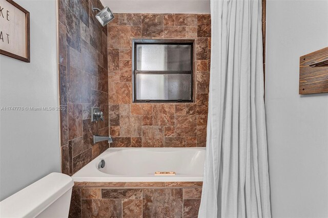 full bath featuring tiled shower / bath combo and toilet