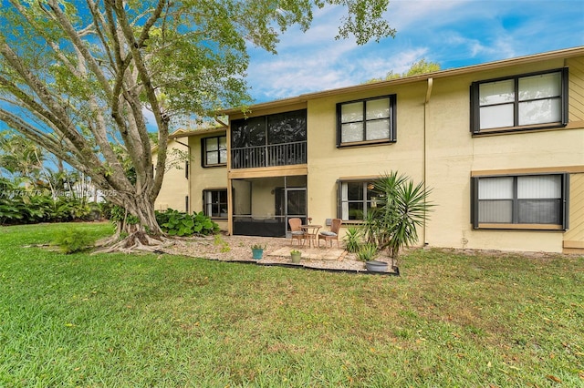 back of house featuring a yard, stucco siding, and a patio
