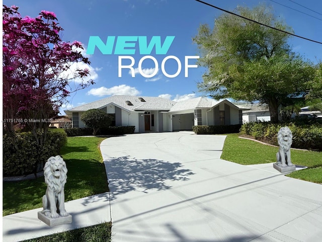 view of front of home with a garage, driveway, and a front lawn