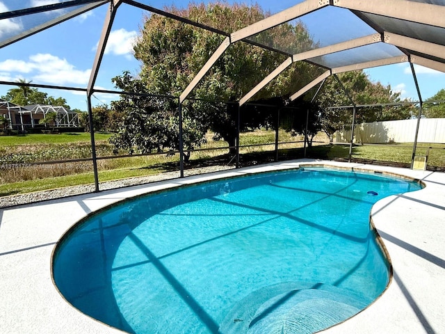 outdoor pool with glass enclosure and a patio area