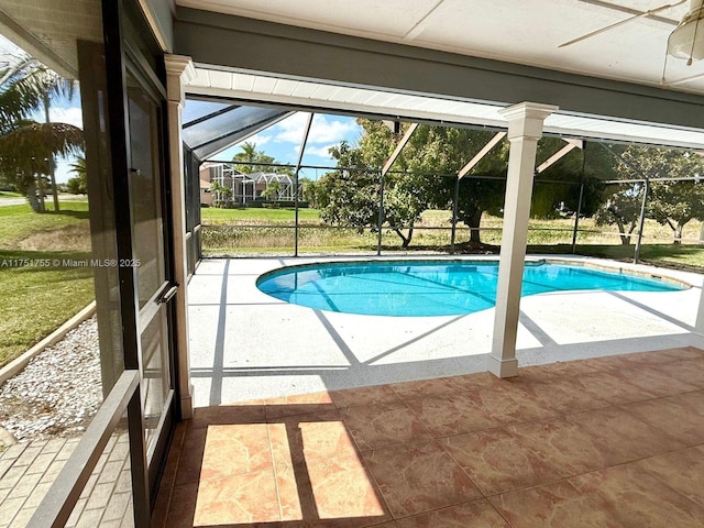 outdoor pool featuring glass enclosure and a patio area