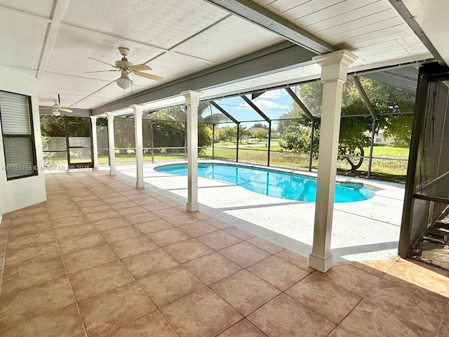 outdoor pool featuring a patio, glass enclosure, and a ceiling fan