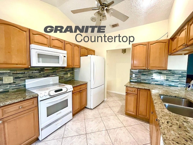 kitchen featuring visible vents, vaulted ceiling, a sink, a textured ceiling, and white appliances