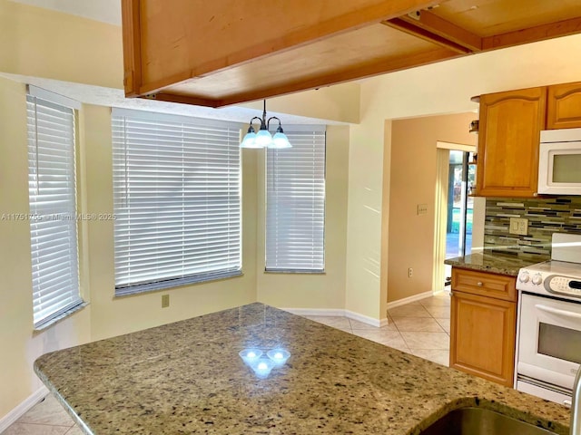 kitchen featuring stone counters, white appliances, light tile patterned flooring, and backsplash