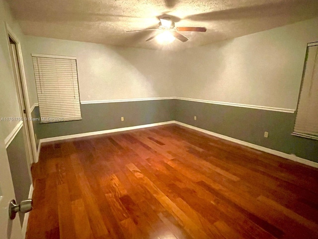 empty room featuring ceiling fan, a textured ceiling, wood finished floors, and baseboards