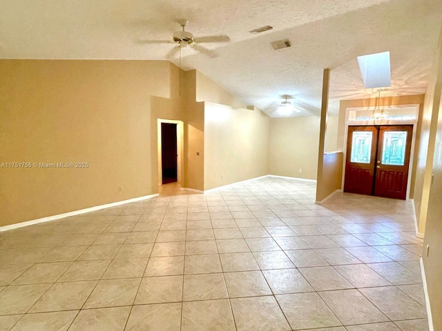 empty room with ceiling fan, lofted ceiling, light tile patterned flooring, visible vents, and baseboards