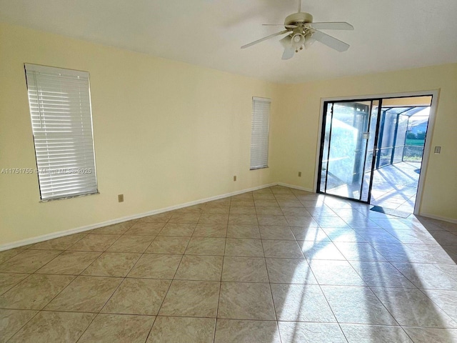 unfurnished room featuring a ceiling fan, baseboards, and light tile patterned floors