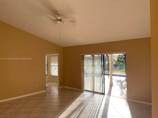 unfurnished room featuring lofted ceiling, light tile patterned floors, ceiling fan, and baseboards