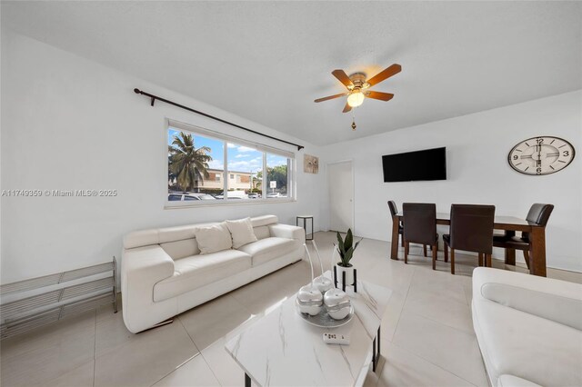 living area with tile patterned flooring and a ceiling fan