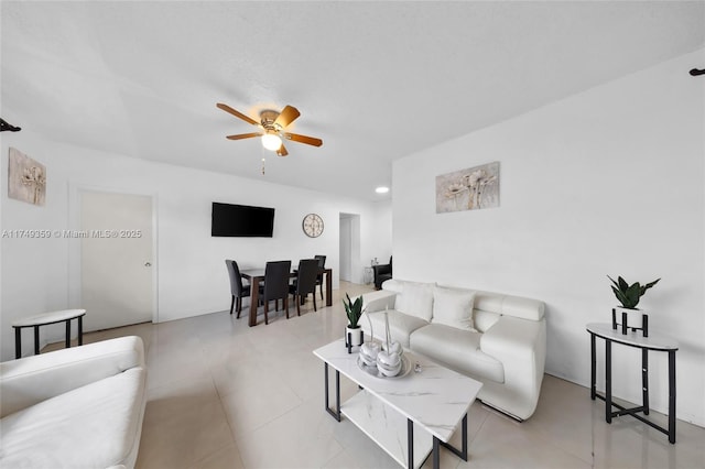 living area featuring light tile patterned floors and a ceiling fan