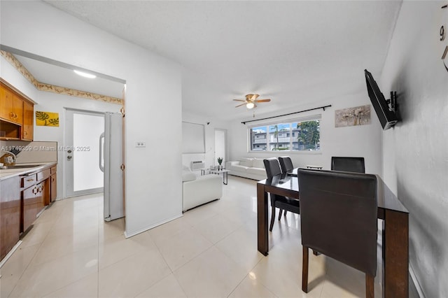 dining area with a ceiling fan and light tile patterned flooring