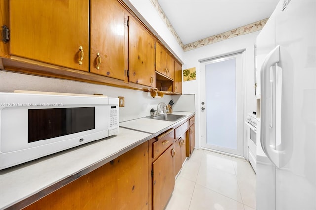 kitchen with white appliances, brown cabinets, light countertops, a sink, and light tile patterned flooring