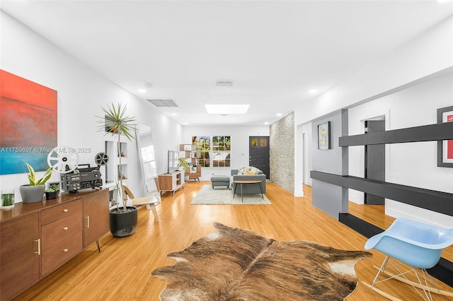 living room with visible vents, a skylight, and light wood-style flooring