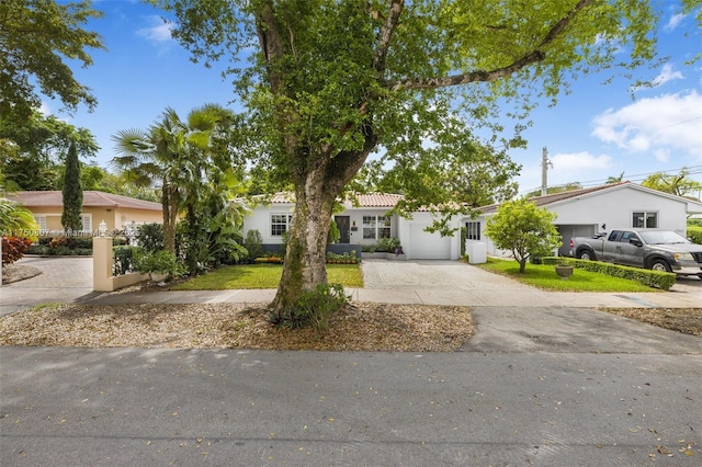 ranch-style home featuring driveway, an attached garage, and a tile roof