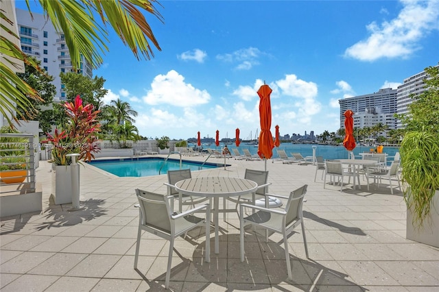 community pool with a water view and a patio area