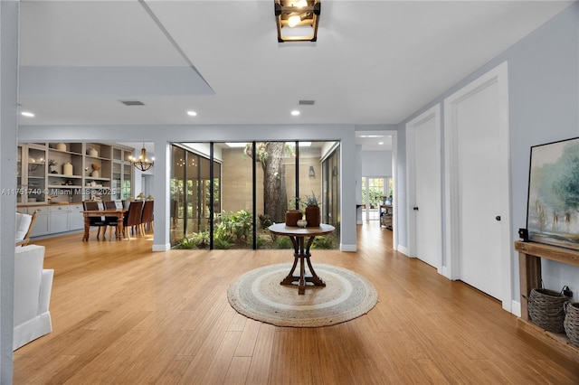 interior space with light wood-style flooring, recessed lighting, a notable chandelier, visible vents, and baseboards