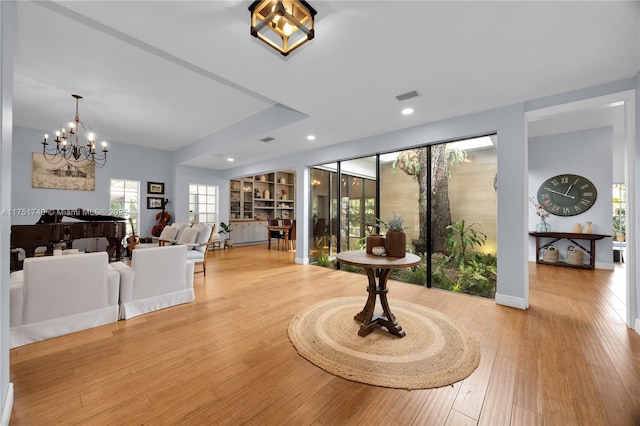 interior space with recessed lighting, wood finished floors, visible vents, baseboards, and an inviting chandelier