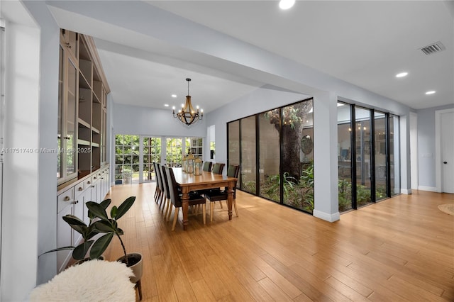 dining area with light wood finished floors, recessed lighting, visible vents, and a notable chandelier