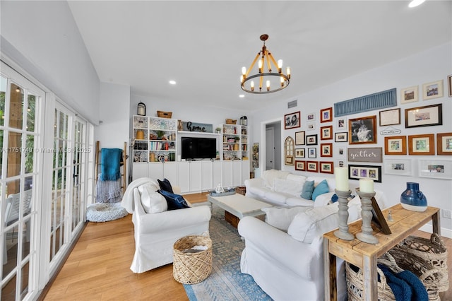 living room featuring a chandelier, recessed lighting, visible vents, french doors, and light wood finished floors