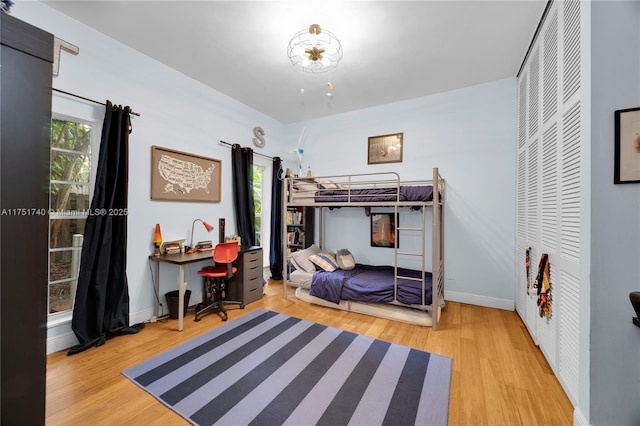 bedroom with multiple windows, baseboards, and wood finished floors