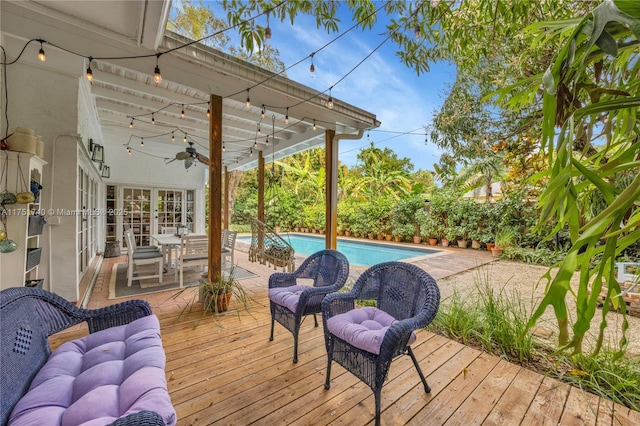 deck with an outdoor hangout area, an outdoor pool, a ceiling fan, and french doors