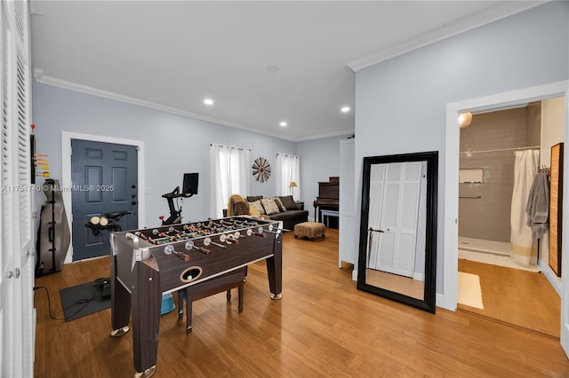 recreation room featuring light wood-style floors, recessed lighting, and crown molding