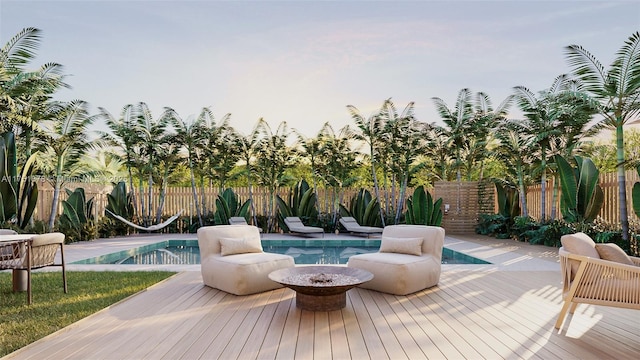 view of swimming pool with a fenced in pool, an outdoor fire pit, a fenced backyard, and a wooden deck