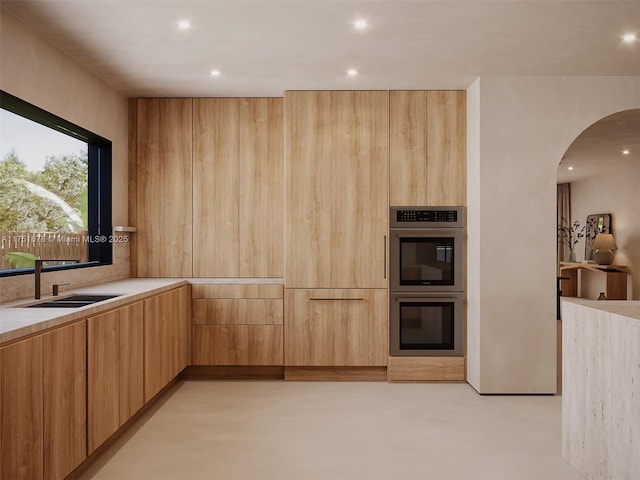 kitchen with light brown cabinets, modern cabinets, light countertops, and stainless steel double oven