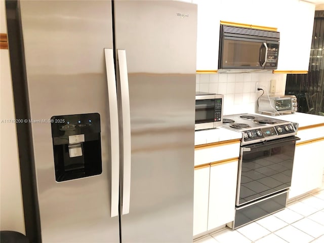 kitchen featuring light tile patterned floors, decorative backsplash, stainless steel appliances, light countertops, and white cabinetry