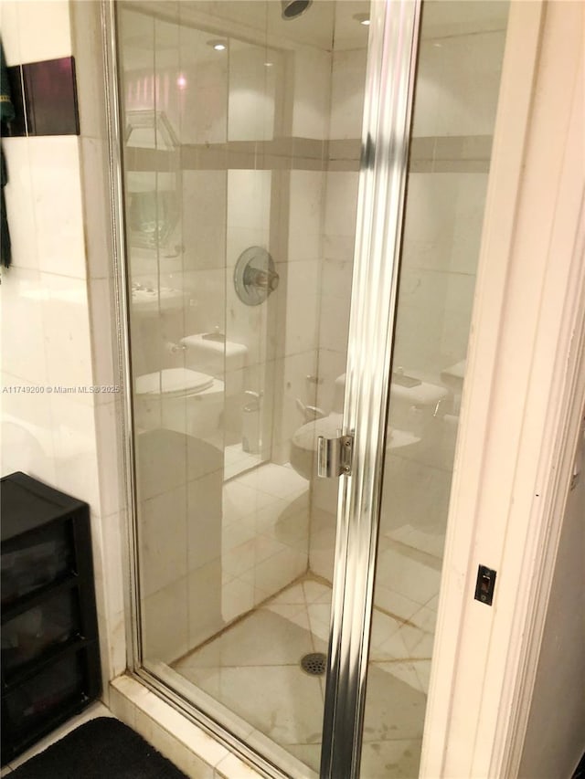 bathroom with a stall shower and toilet