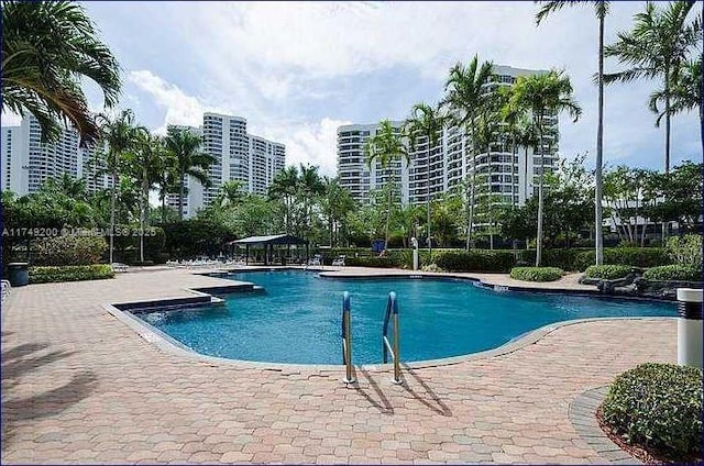 community pool with a view of city and a patio area