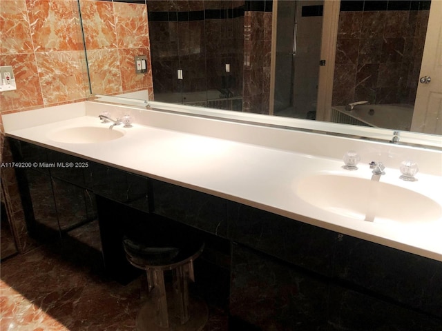 full bathroom featuring marble finish floor, vanity, and tile walls