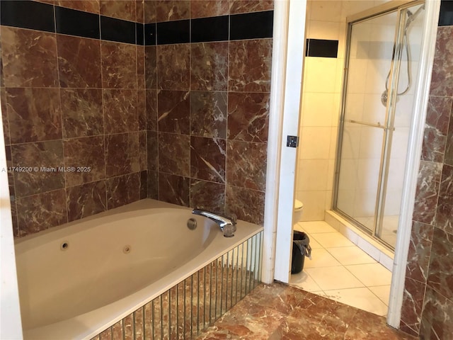 bathroom with tile patterned flooring, a jetted tub, toilet, tile walls, and a stall shower