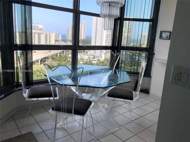 dining space with a city view, tile patterned flooring, and a notable chandelier