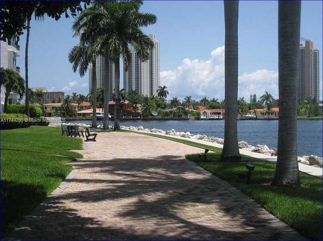 view of home's community with a water view and a yard