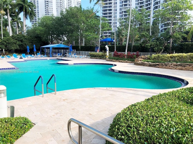 community pool featuring fence, a patio area, and a gazebo