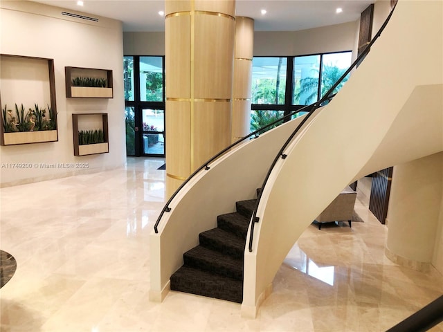 stairs with recessed lighting, a healthy amount of sunlight, and marble finish floor