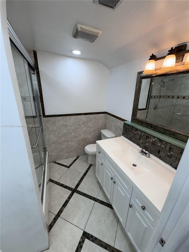 bathroom with toilet, a shower with shower door, vanity, and tile patterned floors