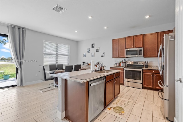 kitchen featuring stainless steel appliances, a healthy amount of sunlight, visible vents, and a sink