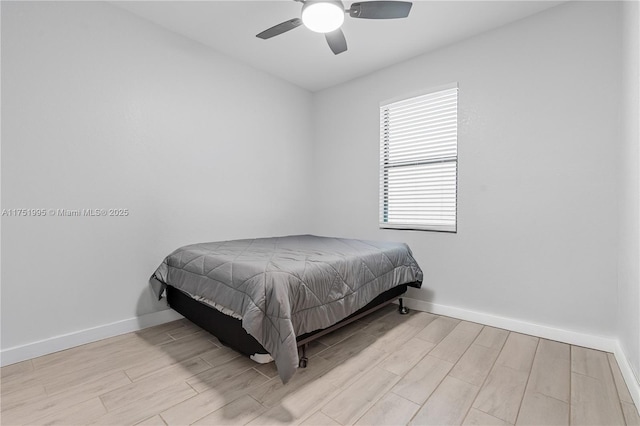 bedroom with ceiling fan, baseboards, and wood finished floors