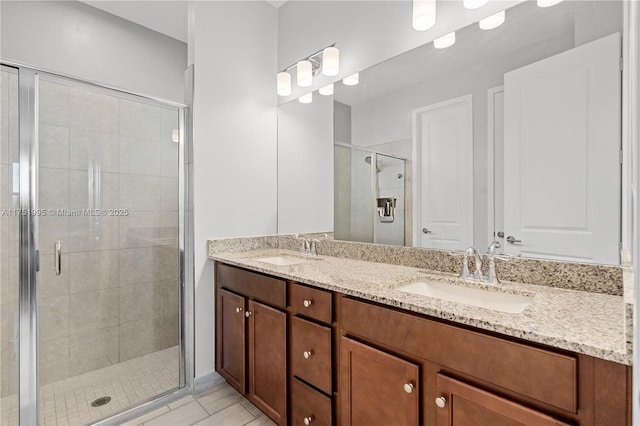 full bath featuring double vanity, tile patterned flooring, a shower stall, and a sink