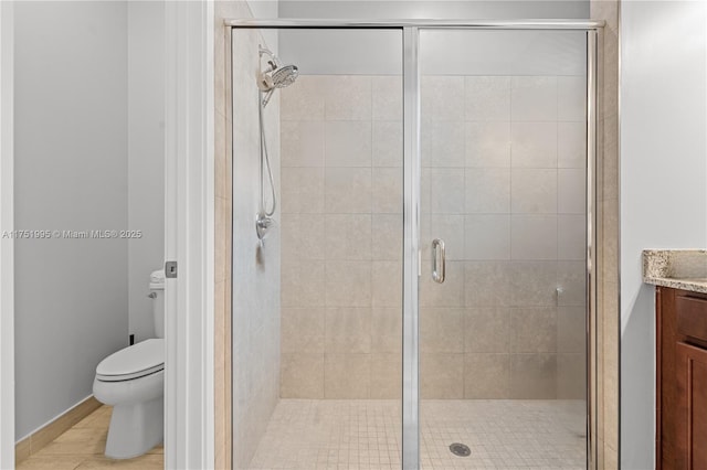 bathroom with a stall shower, vanity, and toilet