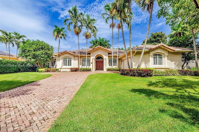 16721 SW 86th Ct, Palmetto Bay, FL 33157 - mediterranean / spanish-style house featuring decorative driveway, stucco siding, a front lawn, and a tiled roof