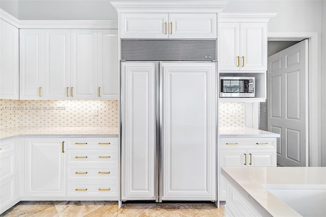 16721 SW 86th Ct, Palmetto Bay, FL 33157 - kitchen with built in appliances, white cabinets, light stone counters, and backsplash