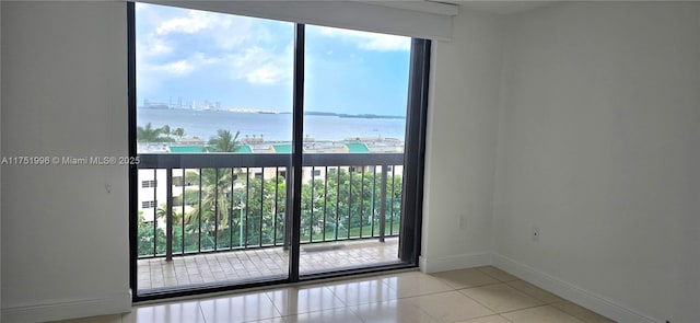 interior space featuring a water view, baseboards, and tile patterned floors