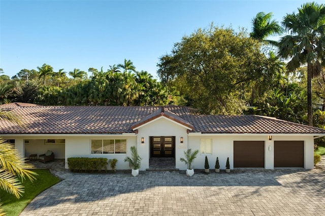 6784 SW 97th St, Pinecrest, FL 33156 - view of front of property featuring french doors, stucco siding, a tiled roof, and decorative driveway