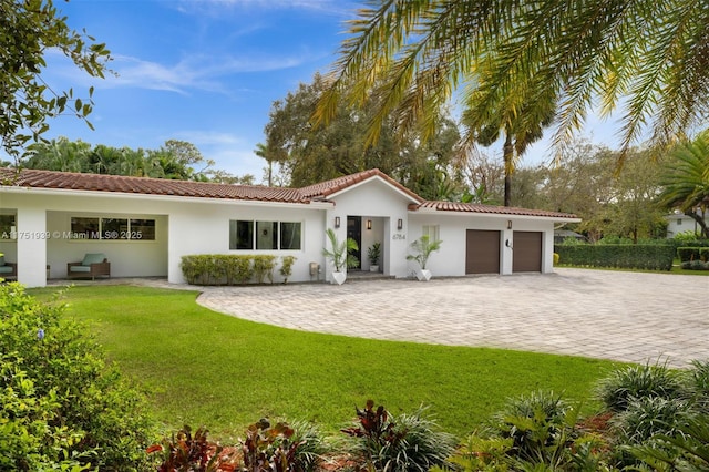 6784 SW 97th St, Pinecrest, FL 33156 - mediterranean / spanish home featuring an attached garage, a tile roof, a front lawn, and driveway