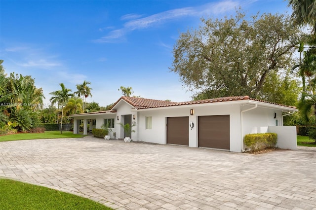 6784 SW 97th St, Pinecrest, FL 33156 - mediterranean / spanish home featuring an attached garage, decorative driveway, stucco siding, and a tile roof