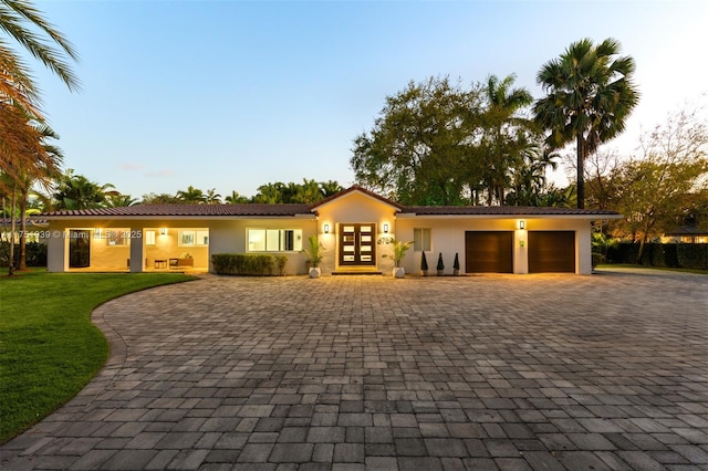 6784 SW 97th St, Pinecrest, FL 33156 - ranch-style home featuring french doors, a garage, decorative driveway, a front yard, and stucco siding