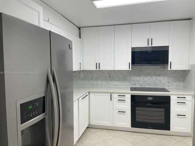 kitchen featuring light tile patterned floors, black appliances, light countertops, and white cabinets